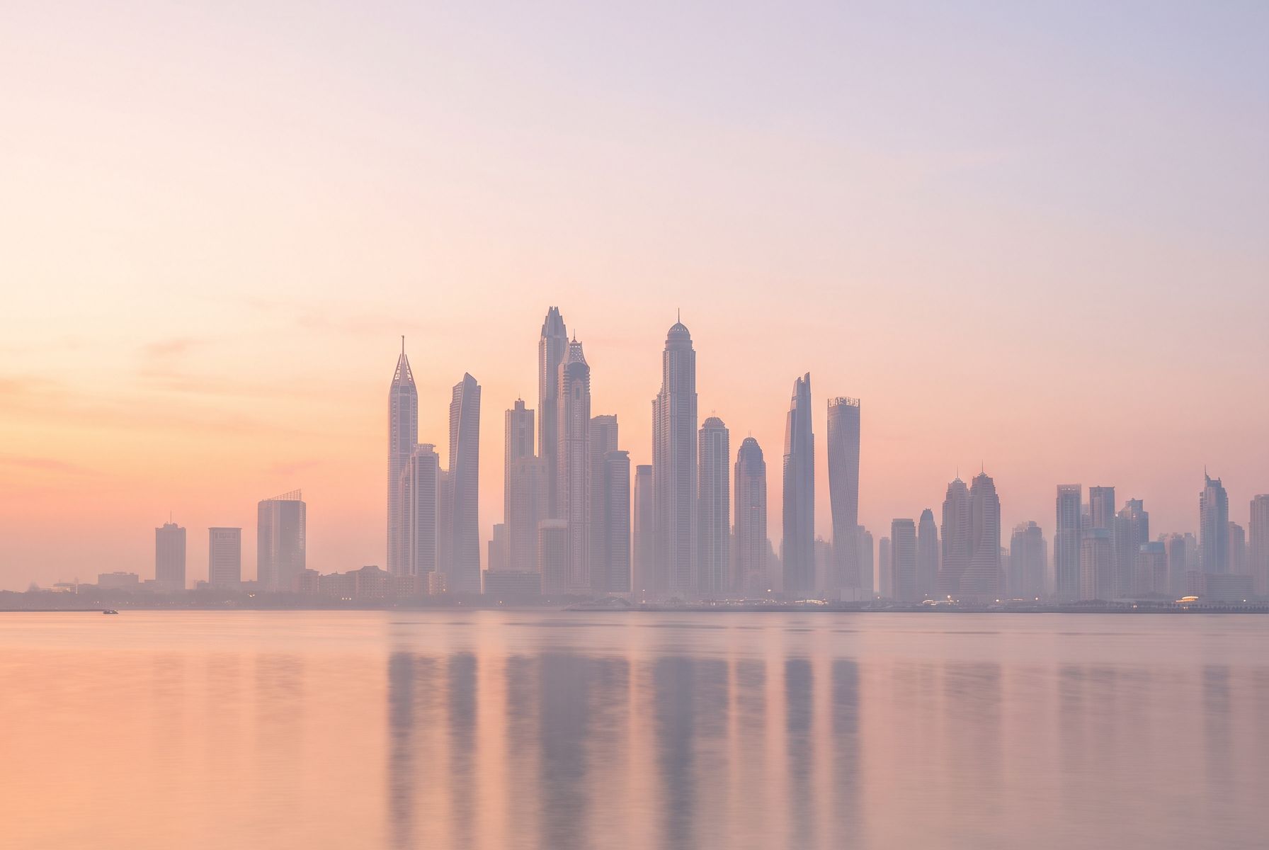 Dubai Marina skyline reflected in calm water at sunrise